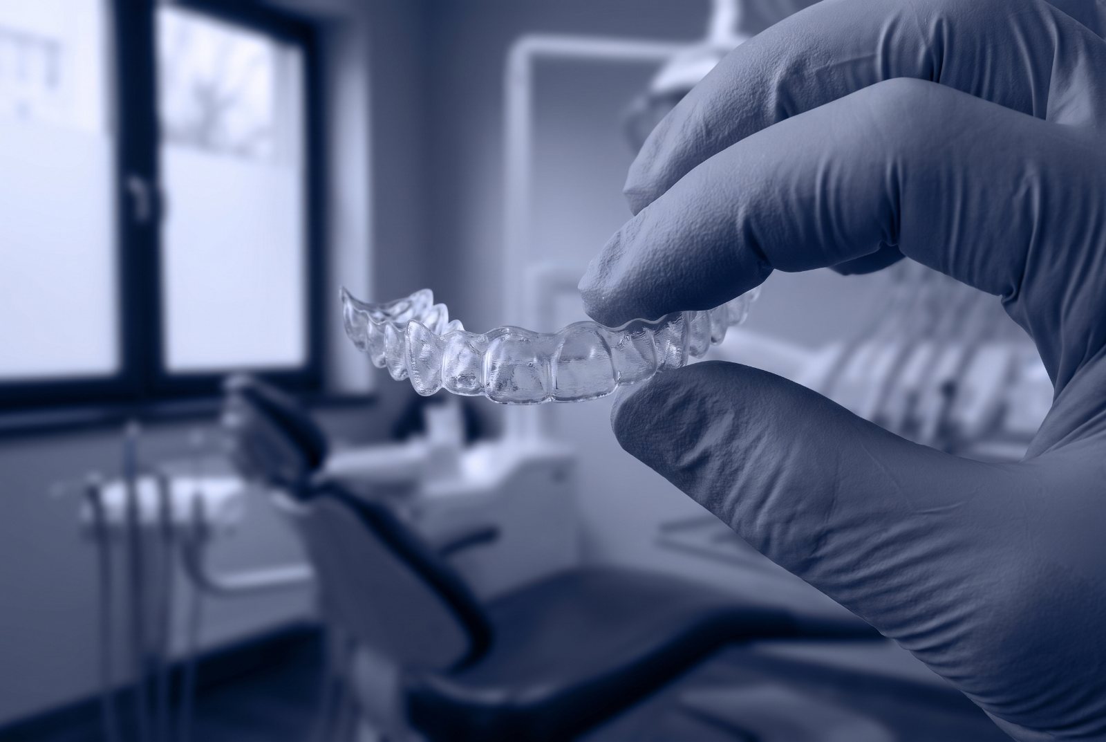 A finished aligner tray held to the light